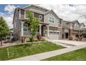 Beautiful two-story home boasting stone accents, a covered porch, and a green lawn at 8240 S White Crow St, Aurora, CO 80016