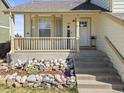 Close up of a cozy front porch with decorative rocks and landscaping surrounding the entrance at 1065 Cobblestone Dr, Highlands Ranch, CO 80126