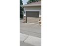 Garage door with neutral color and paneled design, complemented by stone accents at 12711 Colorado Blvd # 1116, Thornton, CO 80241