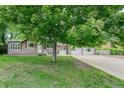 A well-maintained home features mature shade trees, a tidy lawn, and a spacious driveway at 8525 Grandview Ave, Arvada, CO 80002