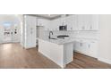 Modern kitchen featuring white cabinets, quartz countertops, and an island at 7210 Watercress Dr, Littleton, CO 80125