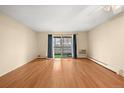 Bright, airy living room showcasing hardwood floors and a private balcony with scenic views at 720 S Clinton St # 1B, Denver, CO 80247