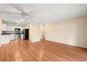 Open-concept living area featuring hardwood floors, a ceiling fan, and a kitchen with modern appliances at 720 S Clinton St # 1B, Denver, CO 80247