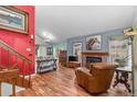 Inviting living room with a cozy brick fireplace and gleaming hardwood floors at 13341 Birch Cir, Thornton, CO 80241