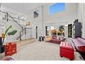 Bright, open-concept living room with two-story ceilings, large windows, and a staircase at 1126 S Davenport Ct, Erie, CO 80516