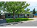 Quaint single-story home featuring a lush green lawn, charming curb appeal, and an attached garage at 5986 Dunraven St, Golden, CO 80403