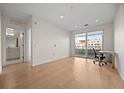 Bright bedroom with hardwood floors, access to a balcony, and an ensuite bathroom at 1616 S Broadway # 206, Denver, CO 80210