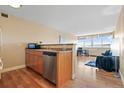 Efficient kitchen featuring stainless steel appliances and hardwood floors flowing into the bright and open living area at 1196 N Grant St # 407, Denver, CO 80203