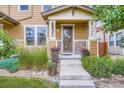 Charming front entrance with stone accents, colorful flowerpots, and concrete steps leading to the front door at 1519 S Dayton St, Denver, CO 80247