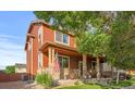 Inviting home exterior with a covered porch, stone accents, an American flag, and mature landscaping at 11034 Nome St, Commerce City, CO 80640