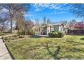 Inviting green cottage with a cozy front porch and lush green lawn at 4476 S Lincoln St, Englewood, CO 80113