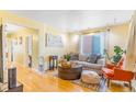 Bright living room with hardwood floors, a neutral sofa, and an orange accent chair at 4476 S Lincoln St, Englewood, CO 80113