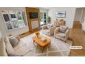 Bright living room featuring a brick fireplace, plush seating, and ample natural light at 3986 S Bahama St, Aurora, CO 80013