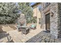 Inviting outdoor patio with a stone fireplace and comfortable seating, surrounded by greenery at 9552 E Silent Hills Pl, Lone Tree, CO 80124