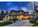 Charming home exterior with stone accents, a spacious driveway, and well-maintained landscaping at 9552 E Silent Hills Pl, Lone Tree, CO 80124