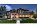 Elegant home exterior featuring beautiful stonework, manicured lawn, and decorative outdoor lighting at 9552 E Silent Hills Pl, Lone Tree, CO 80124