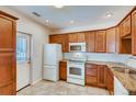Well-lit kitchen features updated appliances, sleek countertops, and wood cabinets at 3818 W 14Th Ave, Denver, CO 80204