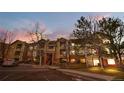 Exterior view of a multi-story apartment complex with brick and siding, landscaped grounds, and private parking at 8422 S Upham Way # G47, Littleton, CO 80128