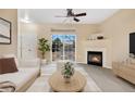 Bright living room with a fireplace, a ceiling fan, and a sliding glass door leading to an outdoor balcony at 8422 S Upham Way # G47, Littleton, CO 80128