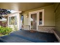 Inviting front porch features a welcome sign and a glass-paneled door that leads to the interior at 7863 W Quarto Ave, Littleton, CO 80128