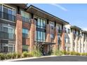 Modern brick apartment building with balconies and landscaping at 155 S Monaco Pkwy # 302, Denver, CO 80224