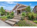 Lovely home showcasing landscaped front yard with stone steps leading to covered front porch at 27485 E Nova Pl, Aurora, CO 80016