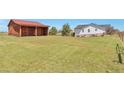 View of a wooden barn with sliding doors, adjacent to a fenced-in grassy area at 1740 Territory Cir, Parker, CO 80138