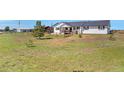 Ranch home featuring a covered front porch, nestled within a large green grassy yard and wooden fence at 1740 Territory Cir, Parker, CO 80138