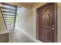 Apartment entrance with wooden door, cement floor, and exterior stairway at 9700 E Iliff Ave # C20, Denver, CO 80231