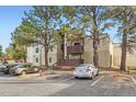 Tan apartment building with balconies, shade trees, and marked parking spaces at 9700 E Iliff Ave # C20, Denver, CO 80231