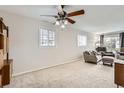 Spacious living room featuring neutral colors, a ceiling fan, and natural light at 1011 Uvalda St, Aurora, CO 80011
