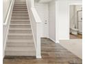 Neutral staircase leading to a white door and a glimpse of the bathroom at 14422 Pansy Loop, Morrison, CO 80465