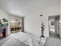 Bright living room featuring a cozy fireplace, neutral carpet, and sliding glass doors to a balcony at 1094 S Dearborn St # 301, Aurora, CO 80012