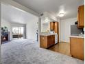 Open concept living room and kitchen with fireplace, neutral carpet, and modern appliances at 1094 S Dearborn St # 301, Aurora, CO 80012