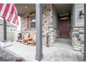 Inviting front porch with stone accents and Adirondack chairs, perfect for relaxing at 7108 Morrison Dr, Frederick, CO 80530