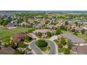 Aerial view of a luxury home with a circular driveway surrounded by a lush, green neighborhood at 2378 Plumb Pl, Erie, CO 80516