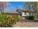 Cozy house with charming details, featuring a two-car garage, mature landscaping, and a warm, inviting entrance at 683 Sunnyside St, Louisville, CO 80027