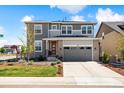 Stylish two-story home featuring a two-car garage, brick accents, and a beautifully landscaped front yard at 8102 S Adams Fork Ave, Littleton, CO 80125