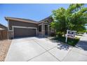 Single-story home featuring a two-car garage and landscaping at 12652 Glencoe St, Thornton, CO 80241
