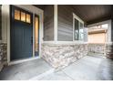 View of the front porch with stone accents and a stylish front door at 12652 Glencoe St, Thornton, CO 80241