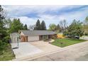 An aerial view of a charming single-story home with a basketball court and green lawn at 10482 W 75Th Ave, Arvada, CO 80005