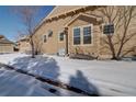 Side yard featuring neutral siding and snowy landscaping on a sunny winter day at 8588 W Quarles Pl, Littleton, CO 80128