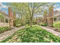 A row of townhomes with brick chimneys and mature trees creating a park-like setting at 1950 S Helena St # D, Aurora, CO 80013
