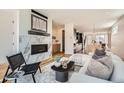 Bright living room featuring a modern fireplace, stylish decor, and an open floor plan at 4211 Vallejo St, Denver, CO 80211