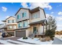 Contemporary two-story townhome with a front-facing two-car garage, landscaped front yard, and covered entryway at 20054 E 48Th Dr, Denver, CO 80249