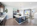 Bright kitchen featuring a large island with stools, modern appliances, and tile flooring throughout at 20054 E 48Th Dr, Denver, CO 80249