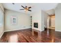 Spacious living room featuring hardwood floors, a cozy fireplace, built-in shelving, and a ceiling fan at 14183 Madison Way, Thornton, CO 80602