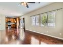 Bright open-concept living room with hardwood floors, large windows, and seamless flow into the kitchen area at 14183 Madison Way, Thornton, CO 80602