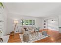 Spacious living room boasts hardwood floors, white walls, a large window and stylish decor at 1475 Kingsbury Ct, Golden, CO 80401