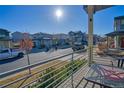 View from balcony overlooking neighborhood street with houses and cars in a suburban community under a bright sky at 5295 Andes St, Denver, CO 80249